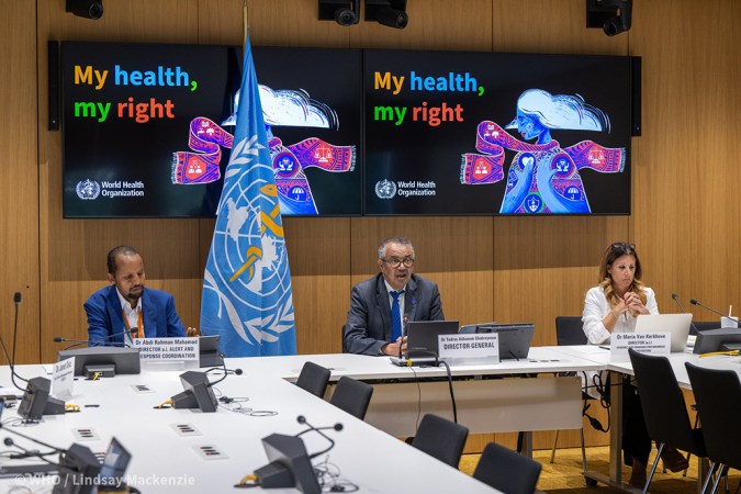 Three public health officials sit at a table during a meeting to decide whether mpx is a global public health emergency.